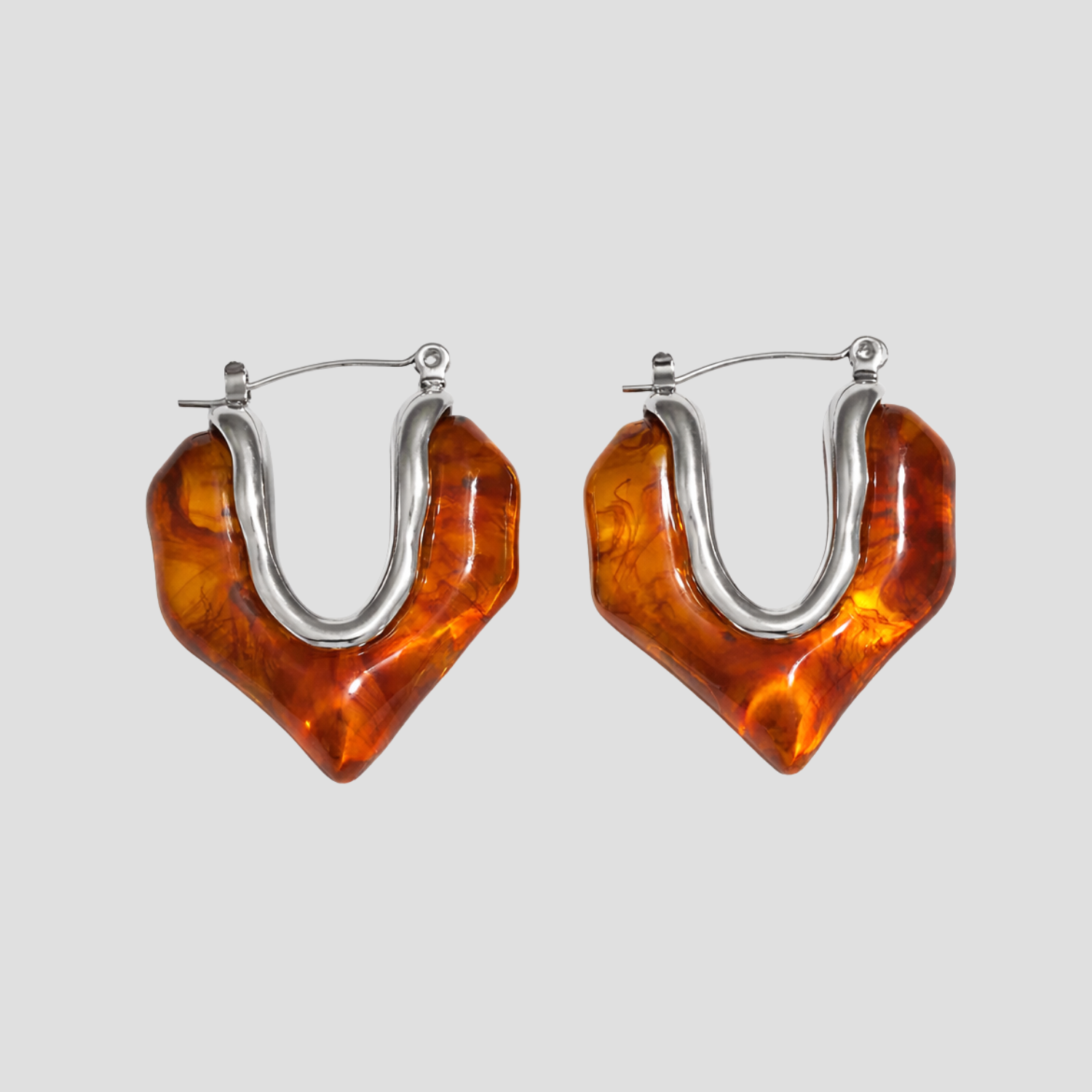 Silver molten heart amber resin hoop earrings on gray background