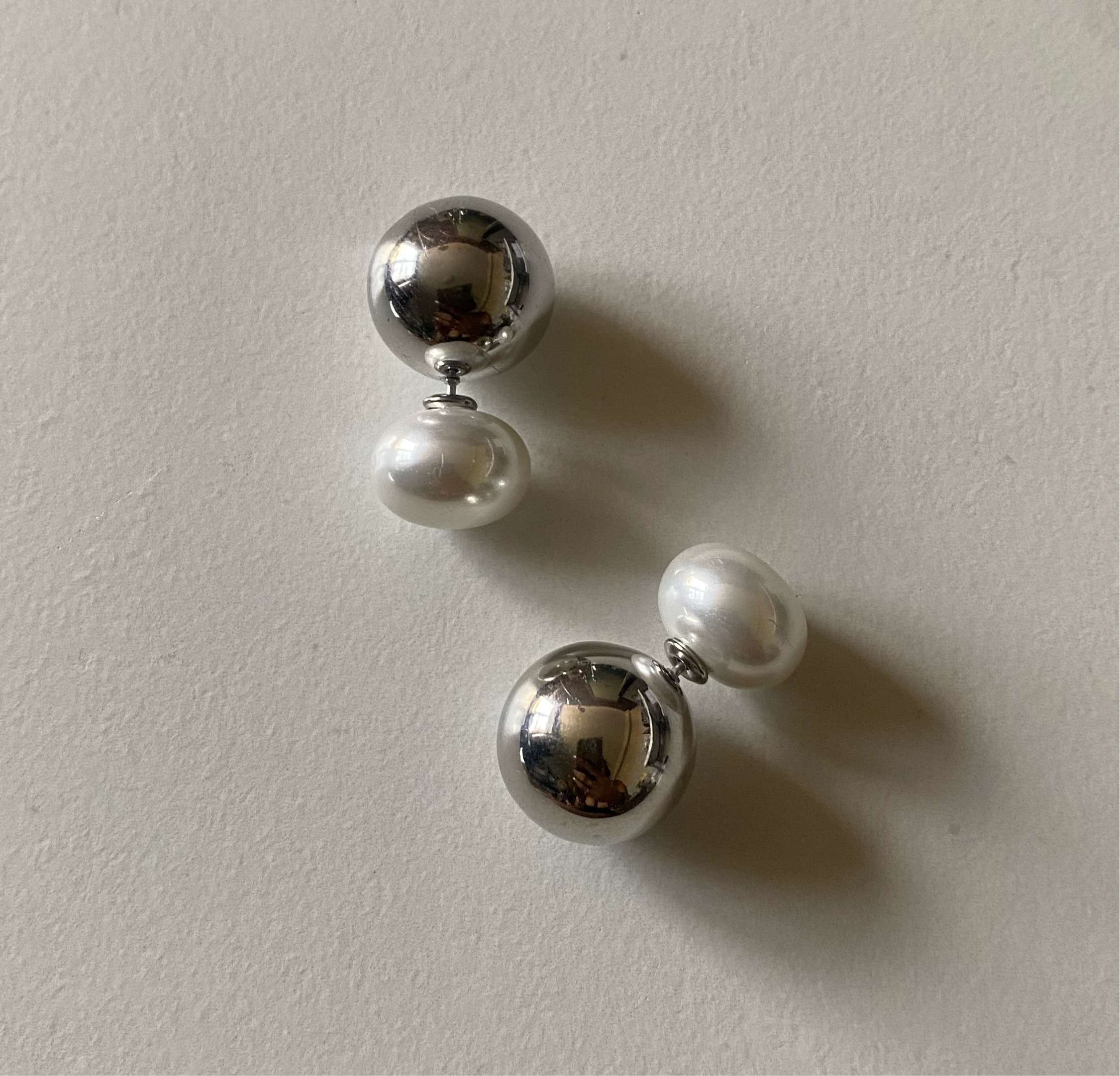 GRISÉ NYC 2 in 1 pearl and stainless steel stud earrings.