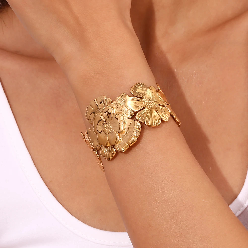 Model wearing GRISÉ NYC embossed flower gold cuff bracelet on wrist.