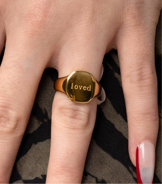 LOVED gold signet ring worn on hand