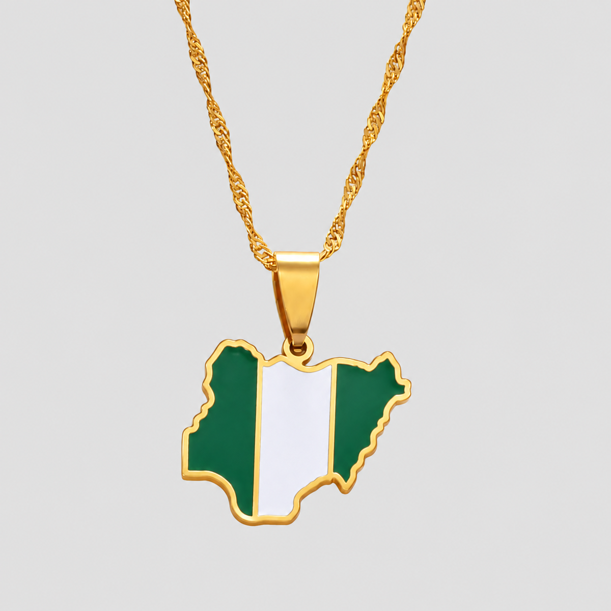 Gold Nigeria flag map pendant necklace by GRISÉ NYC featuring green and white enamel detailing, polished gold-tone edges, and a textured gold chain on a light gray background.