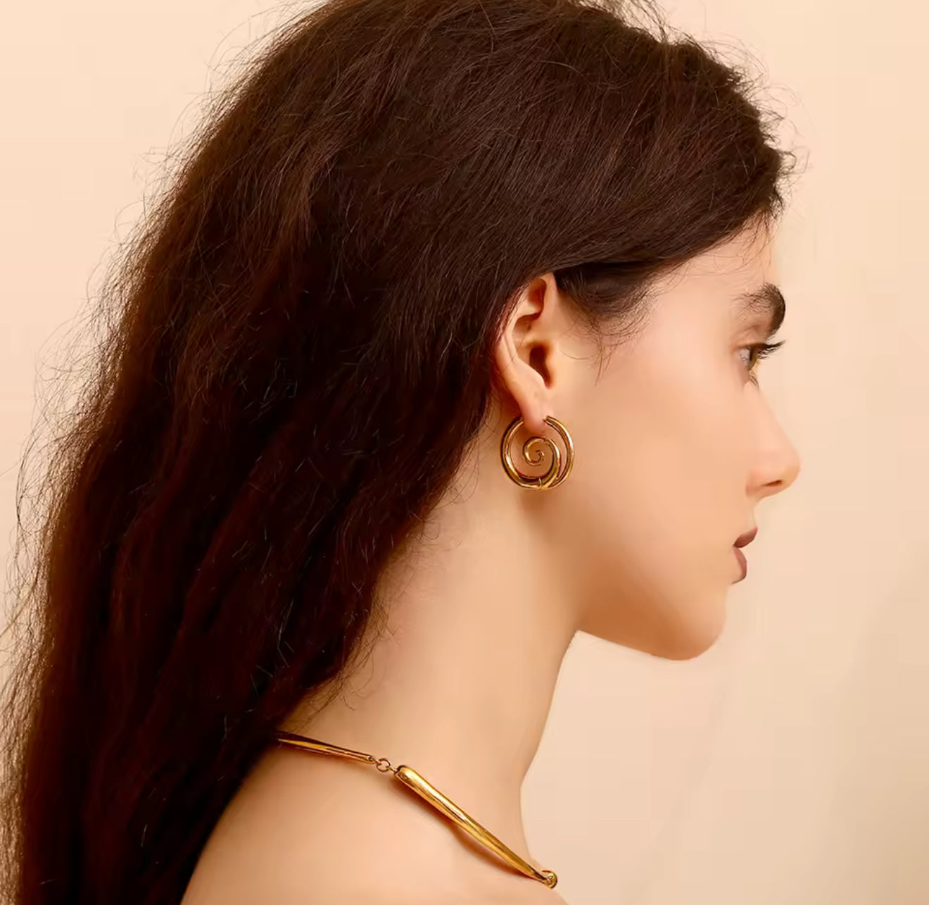 Profile view of model wearing GRISÉ NYC 18k gold spiral hoop earrings statement everyday gold jewelry.