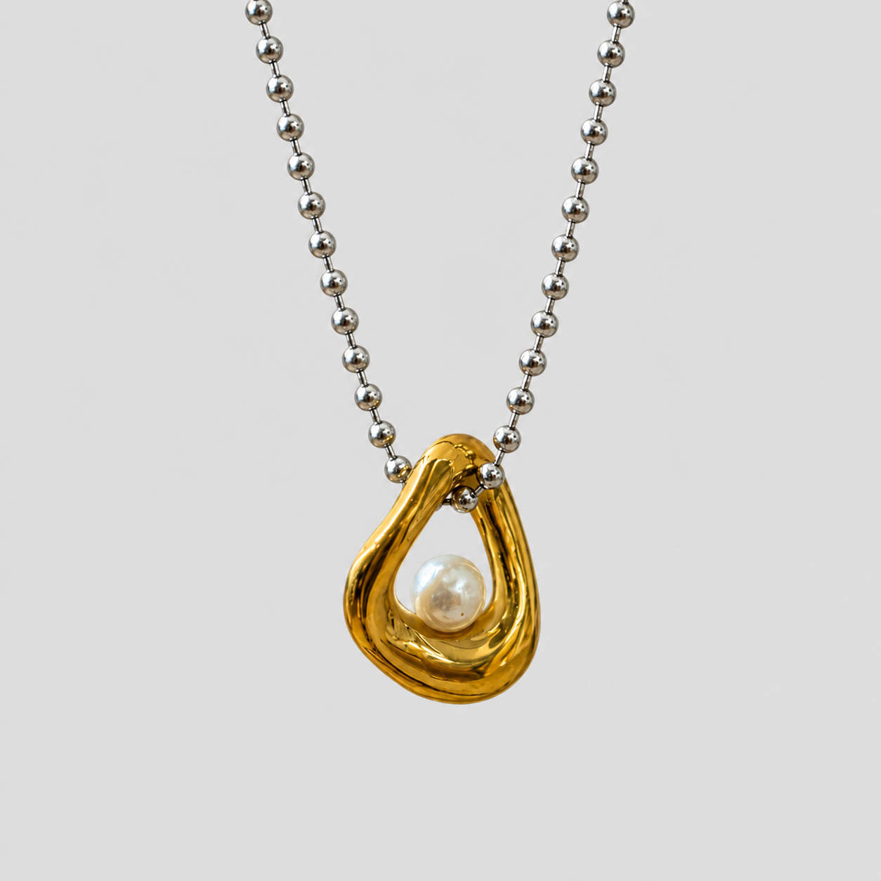 Flat lay of GRISÉ NYC two-tone pearl gold plated necklace.