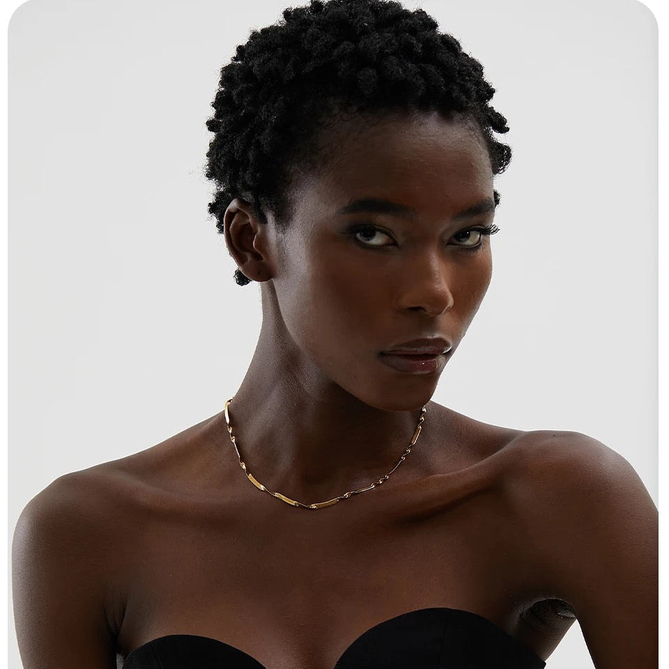 Model wearing twisted snake chain gold necklace by GRISÉ NYC layered minimalist jewelry look.