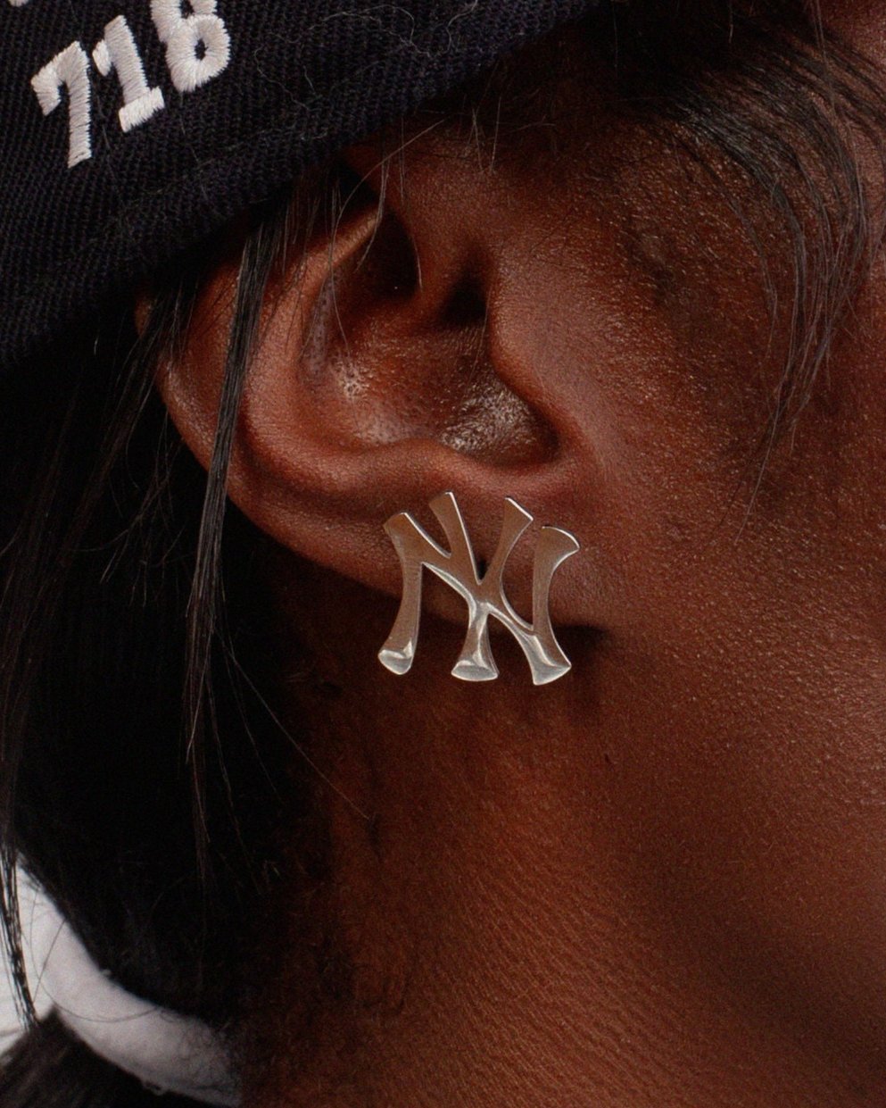 Close up of GRISÉ NYC New York Yankees stainless steel stud earrings in silver featuring sculptural NY logo.