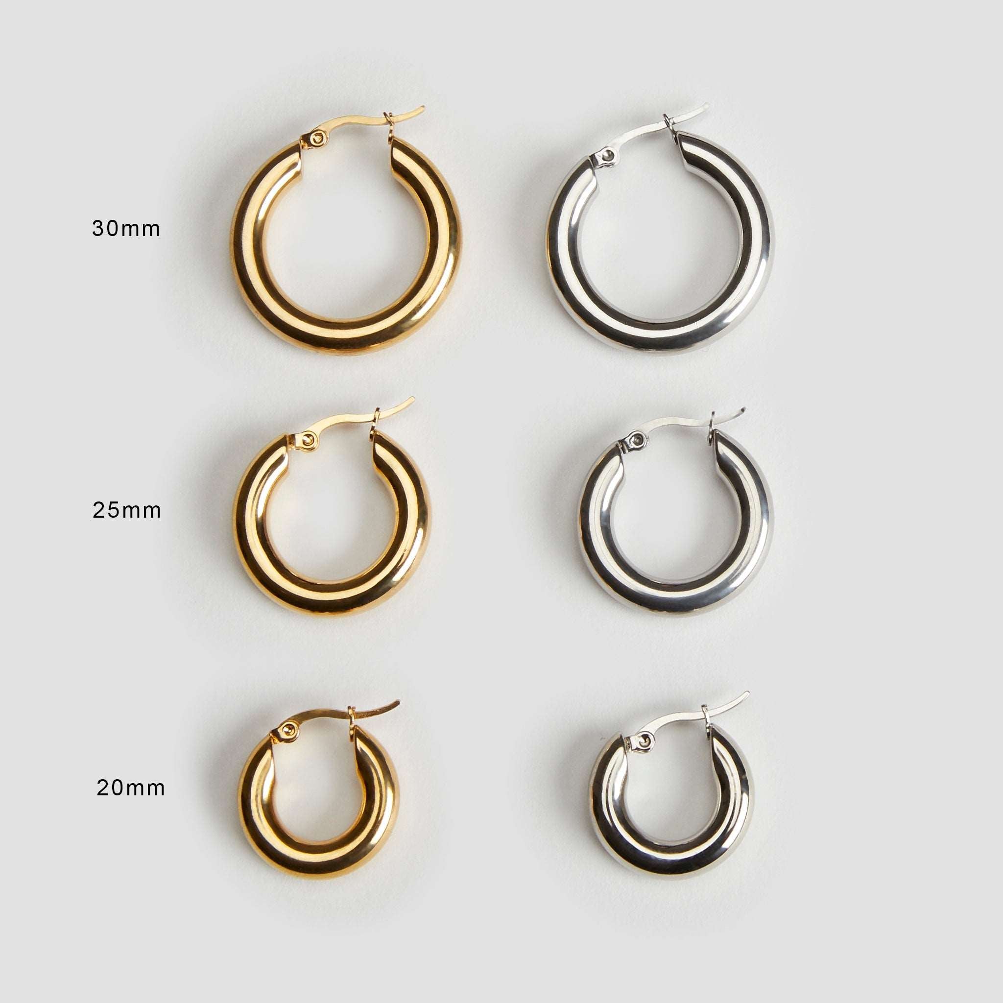 Size comparison guide showing 20 mm, 25 mm, and 30 mm 18K gold and stainless steel mini hoop earrings by GRISÉ NYC.