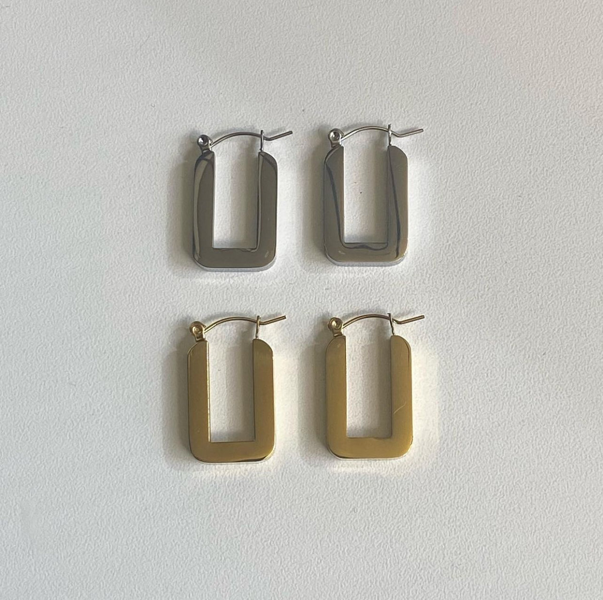 Rectangle hoop earrings in silver and 18k gold plated stainless steel by GRISÉ NYC with bold geometric open rectangular design.