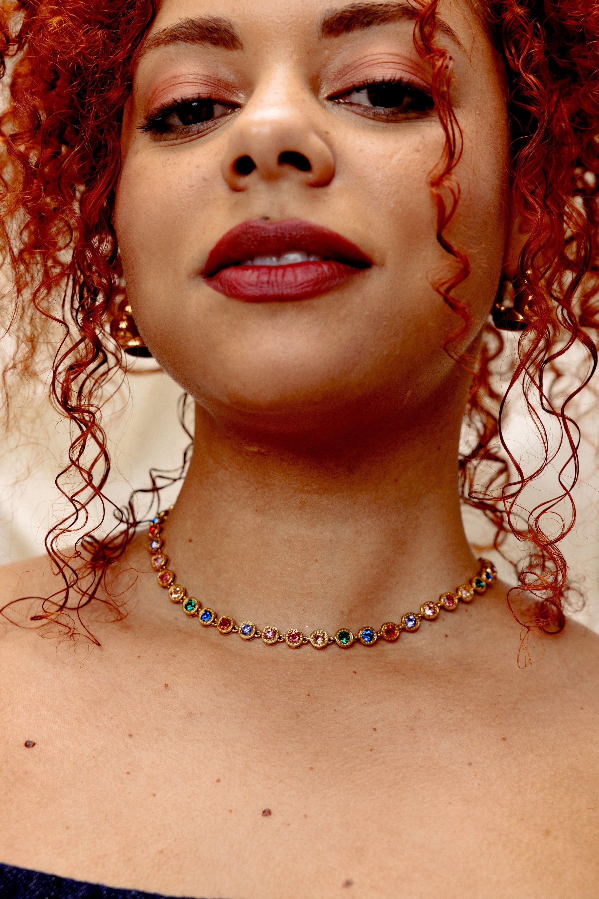 Model wearing Royal 18k gold multicolor gemstone necklace styled as a bold colorful statement choker
