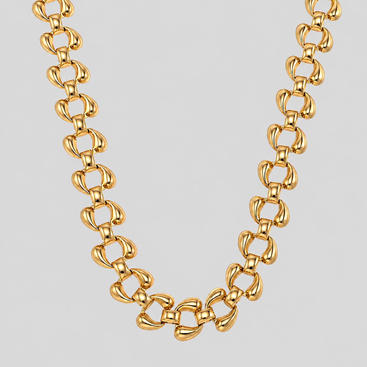 The Sovereign 18k gold plated necklace with a distinctive interlocking loop link design, displayed against a solid light gray background.
