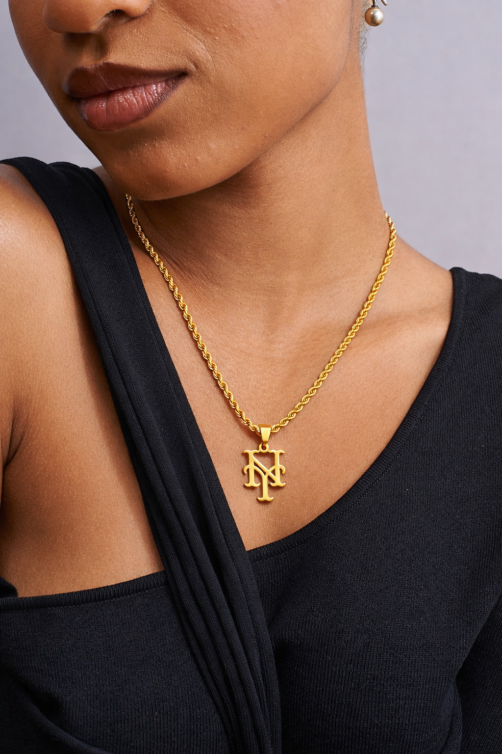 Model wearing 18k yellow gold New York Mets rope necklace with Mets inspired pendant, tarnish resistant stainless steel jewelry by GRISÉ NYC.