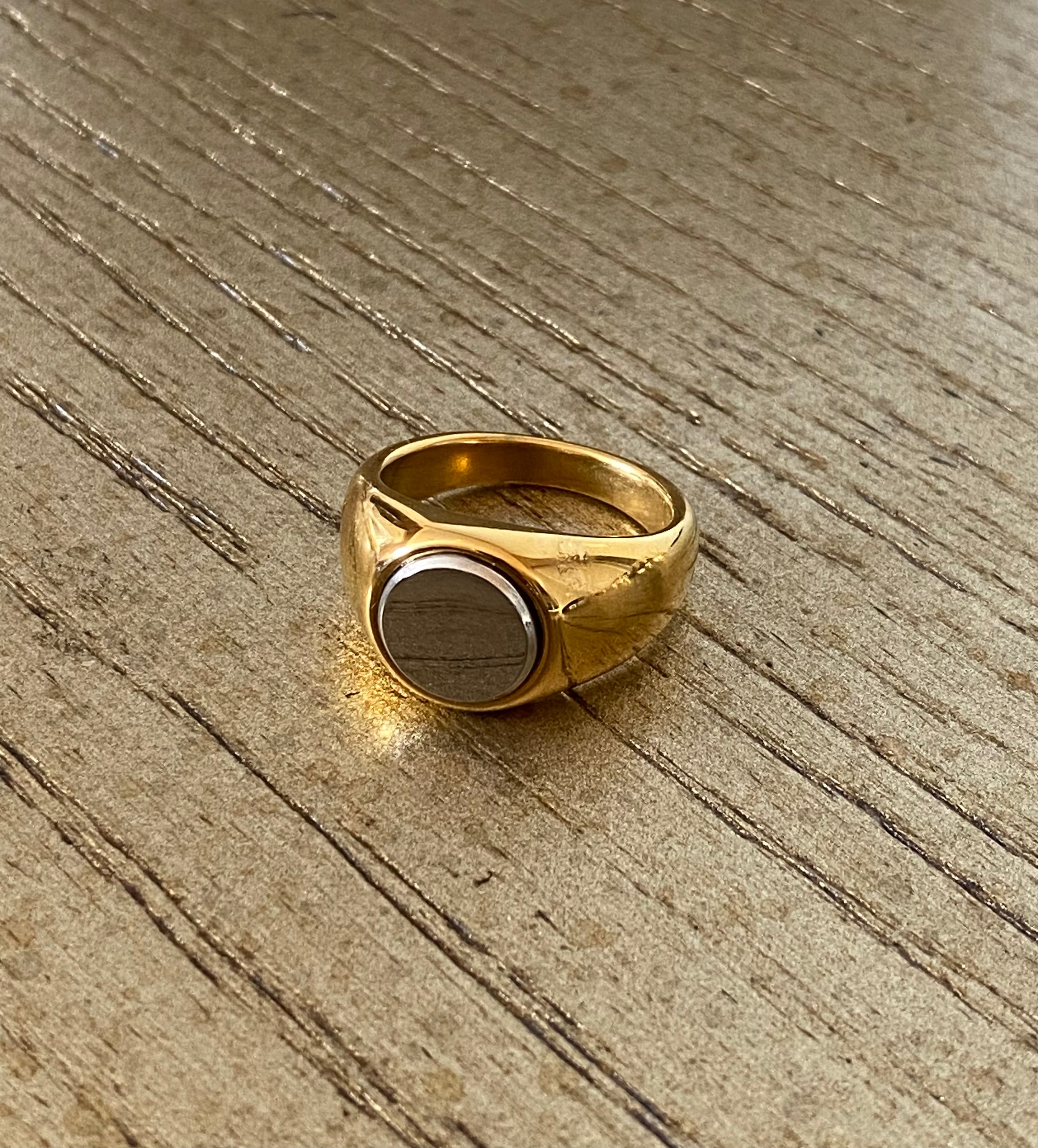 2-Tone Circle Ring by GRISÉ NYC displayed on wood surface highlighting its sculptural gold band and silver center design