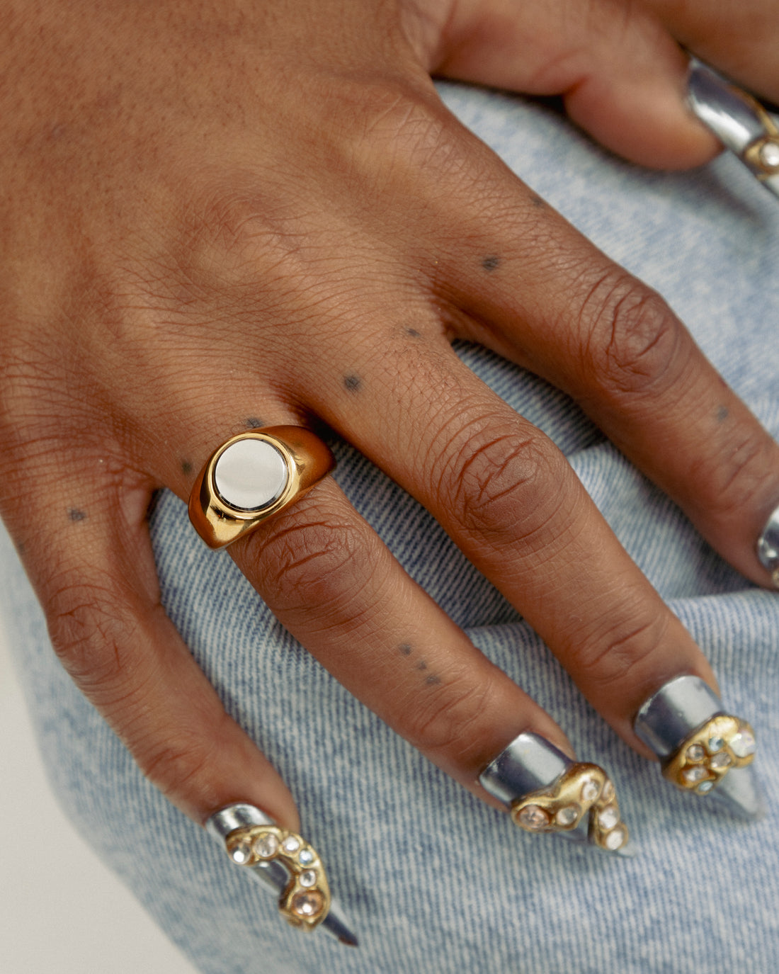 Close up of 2-Tone Circle Ring by GRISÉ NYC worn on hand showcasing bold mixed metal styling with gold and silver tones