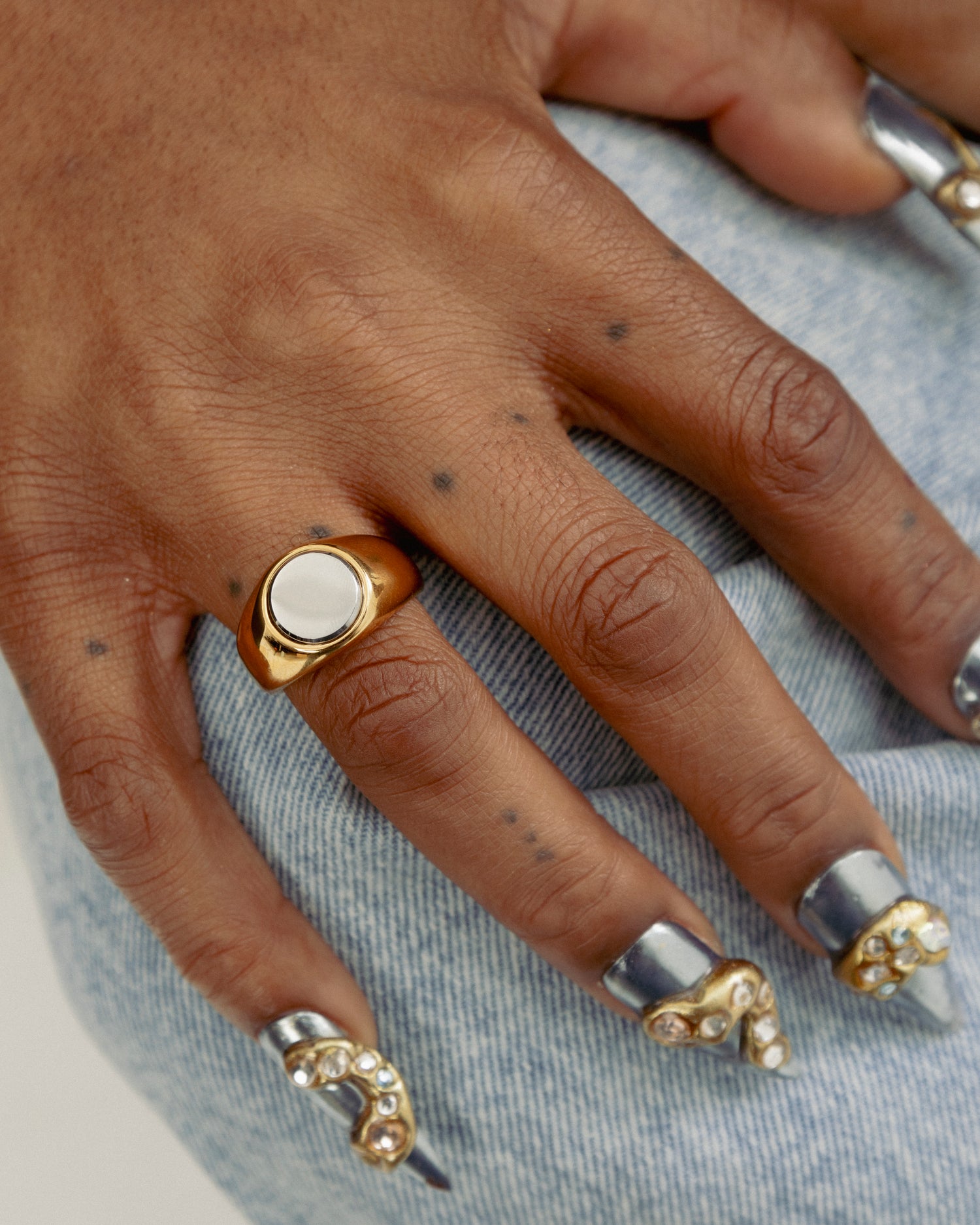 Close up of 2-Tone Circle Ring by GRISÉ NYC worn on hand showcasing bold mixed metal styling with gold and silver tones