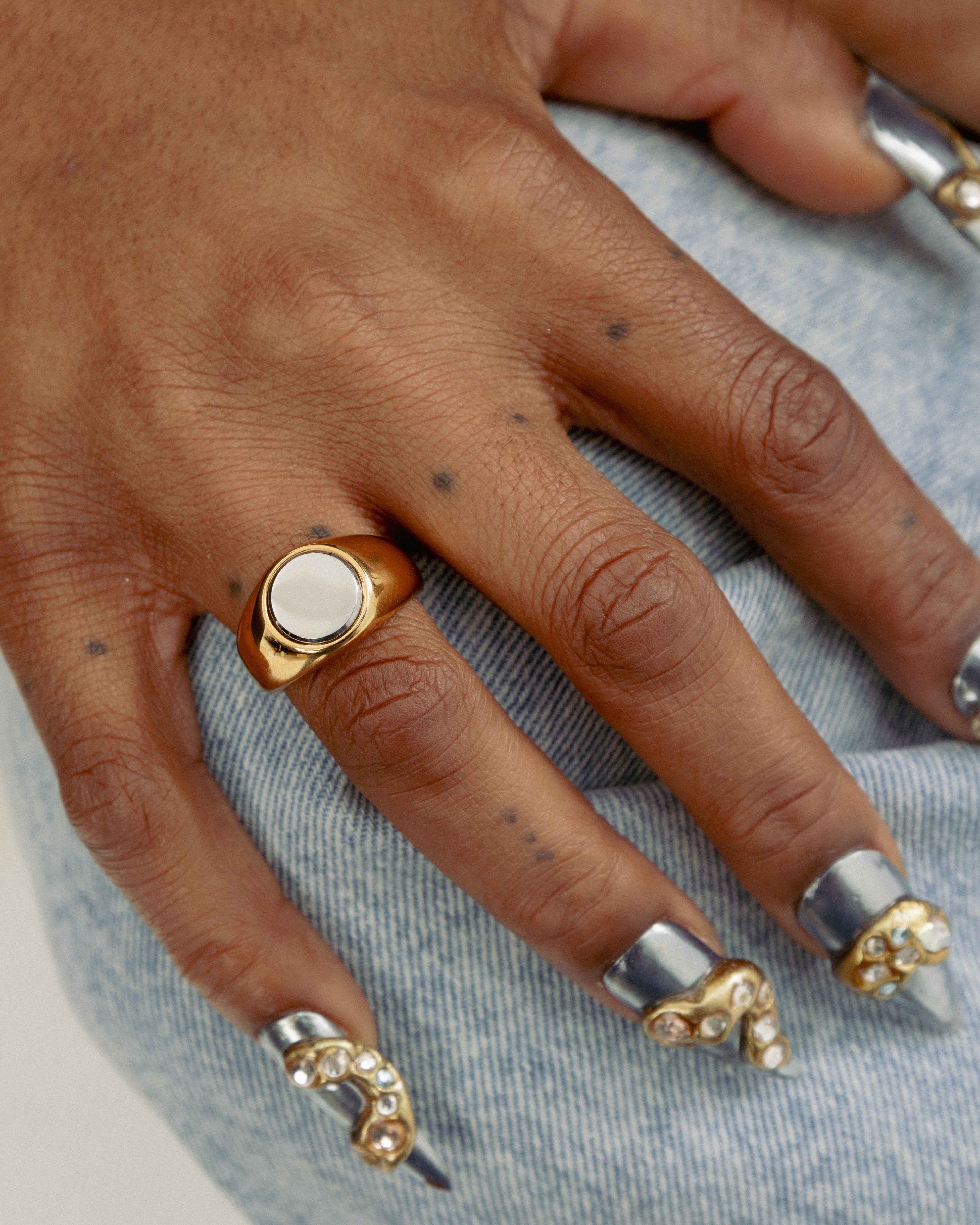 Close up of 2-Tone Circle Ring by GRISÉ NYC worn on hand showcasing bold mixed metal styling with gold and silver tones