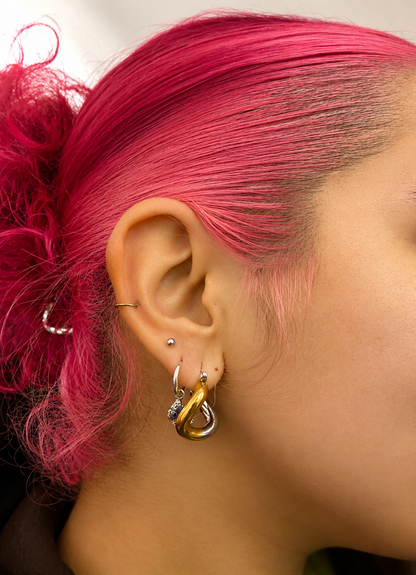 Model wearing the 2-Tone Trapezoid Twist Hoop Earrings featuring polished 18K gold-plated and stainless steel finishes by GRISÉ NYC.