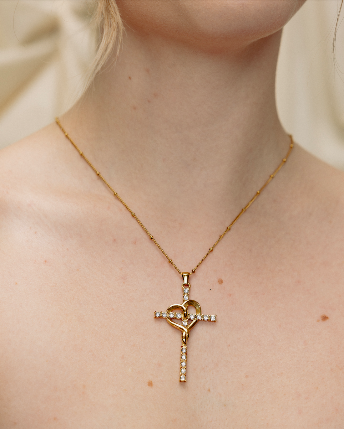 gold amour cross necklace worn on model layering necklace cubic zirconia