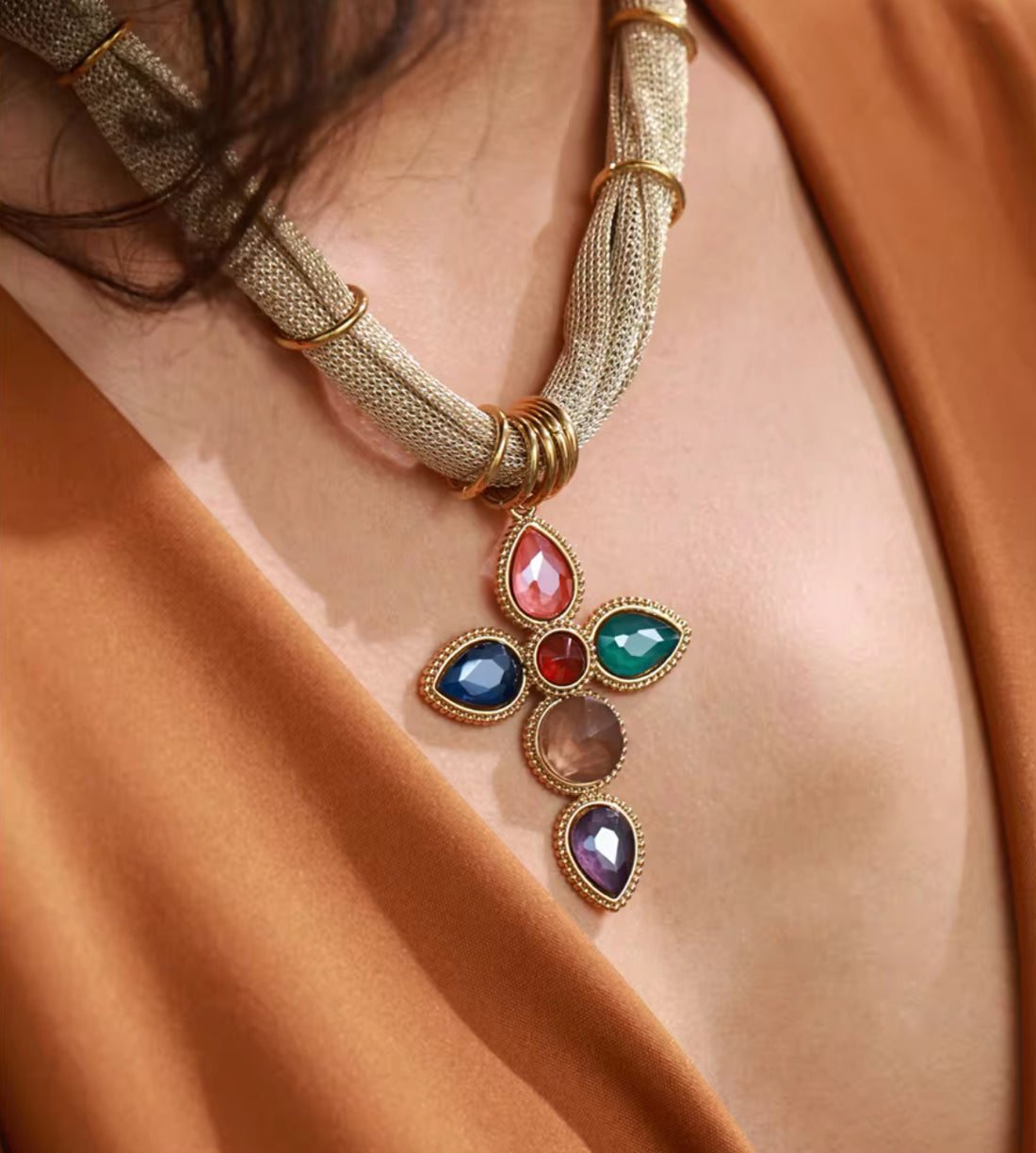 Model wearing gold plated multicolor gemstone cross pendant necklace on mesh chain by GRISE NYC.