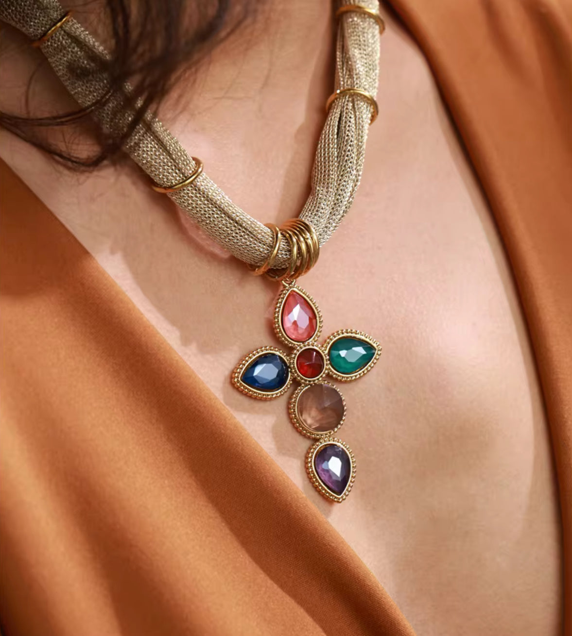 Model wearing gold plated multicolor gemstone cross pendant necklace on mesh chain by GRISE NYC.
