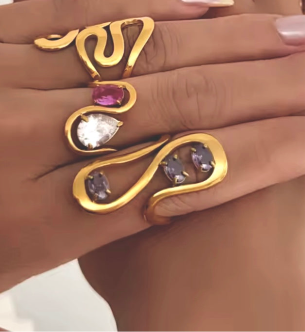 Model hand styled with multiple GRISÉ NYC gold rings including the Aurelia Amethyst Ring, showcasing its wavy shape and gemstone details.