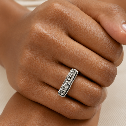 Close up of Babygirl Stainless Steel Ring by GRISÉ NYC worn on hand showcasing bold silver statement styling with moisturized skin detail