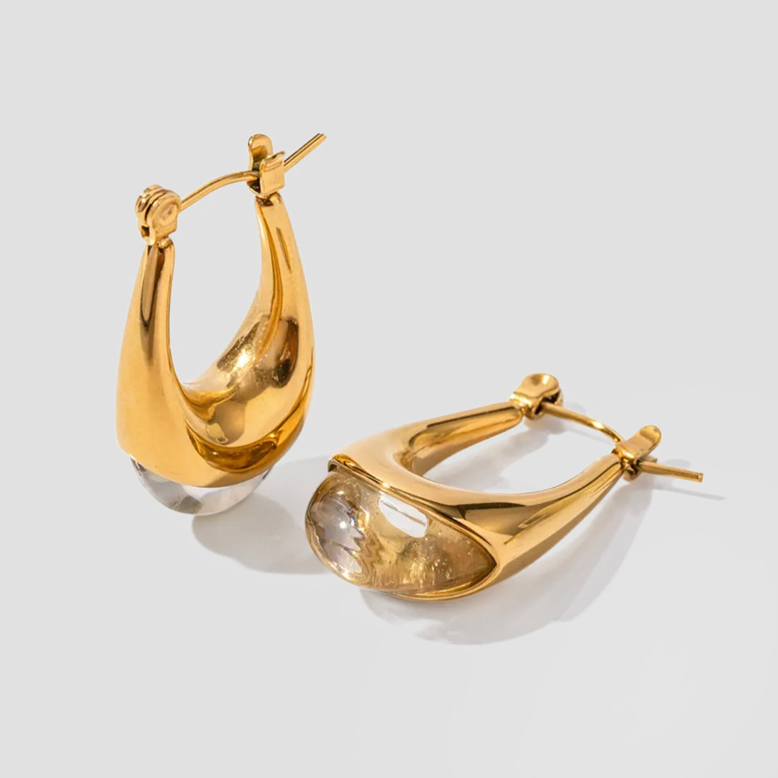 Clear resin oval drop earrings by GRISÉ NYC with 18k gold plated stainless steel hardware and sculptural teardrop silhouette.