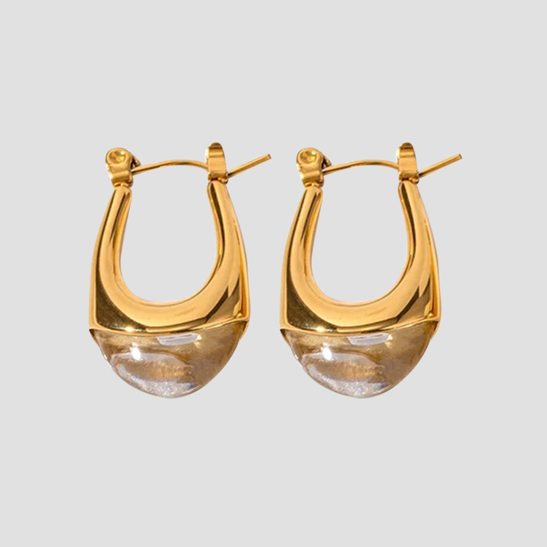Clear resin oval drop earrings by GRISÉ NYC with 18k gold plated stainless steel hardware and sculptural teardrop silhouette.