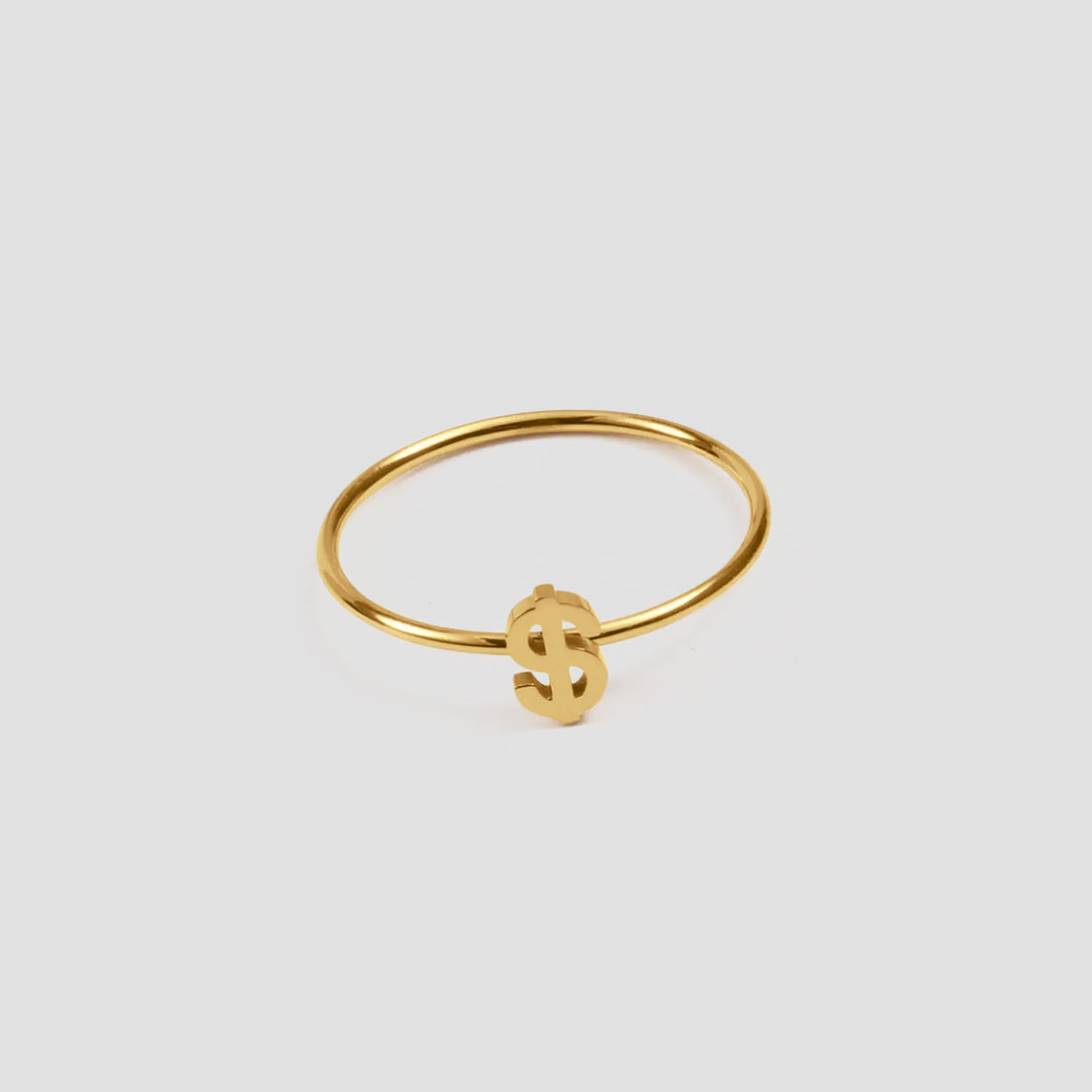 Dainty Money Dollar Ring by GRISÉ NYC featuring a delicate 18k gold plated dollar sign design on a light grey background