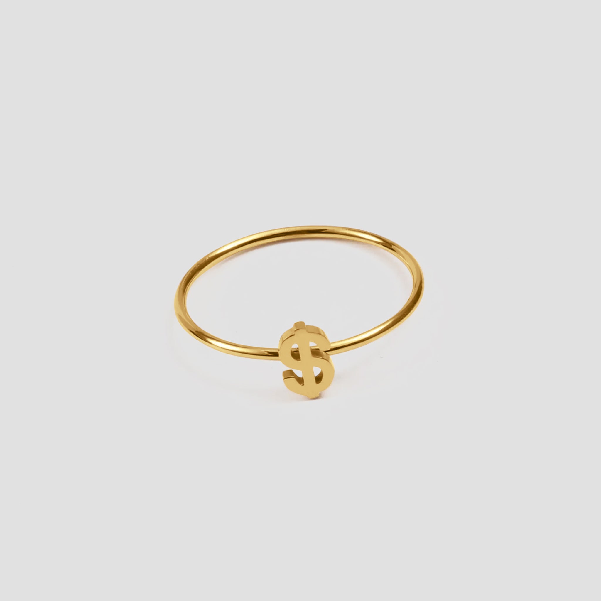 Dainty Money Dollar Ring by GRISÉ NYC featuring a delicate 18k gold plated dollar sign design on a light grey background