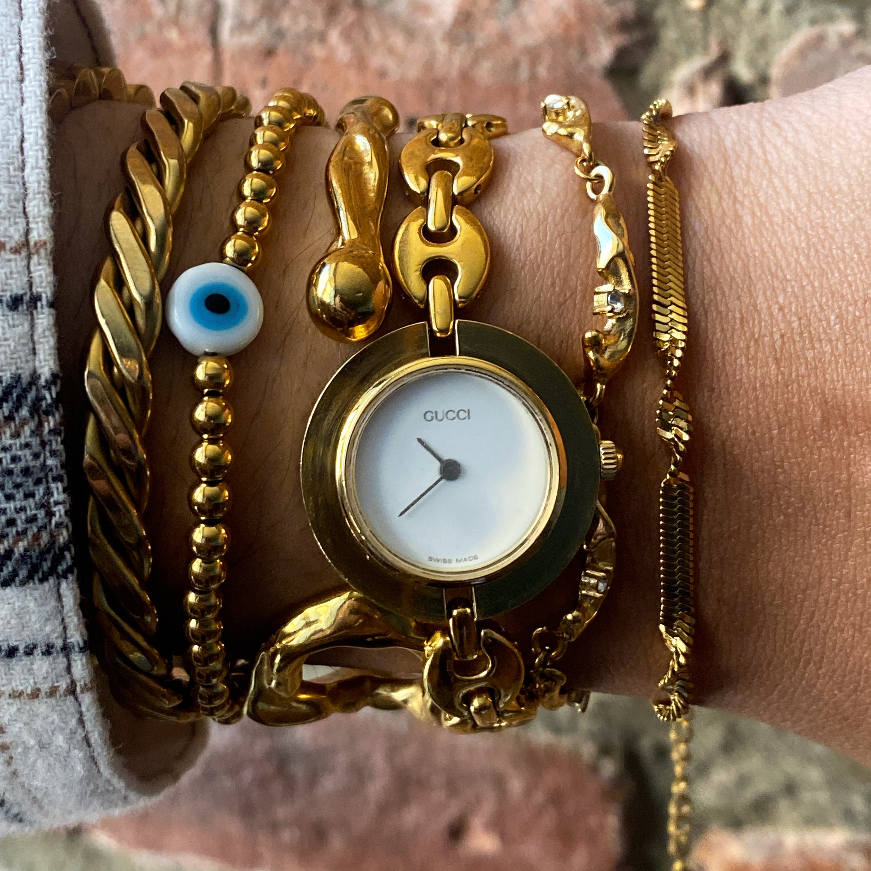 GRISÉ NYC Evil Eye Bead Bracelet layered with gold bracelets for a modern stacked jewelry look.