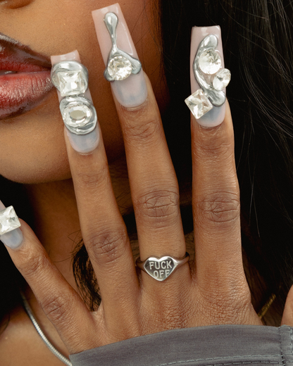 Close-up of a hand wearing multiple silver rings with gemstones on a blurred background