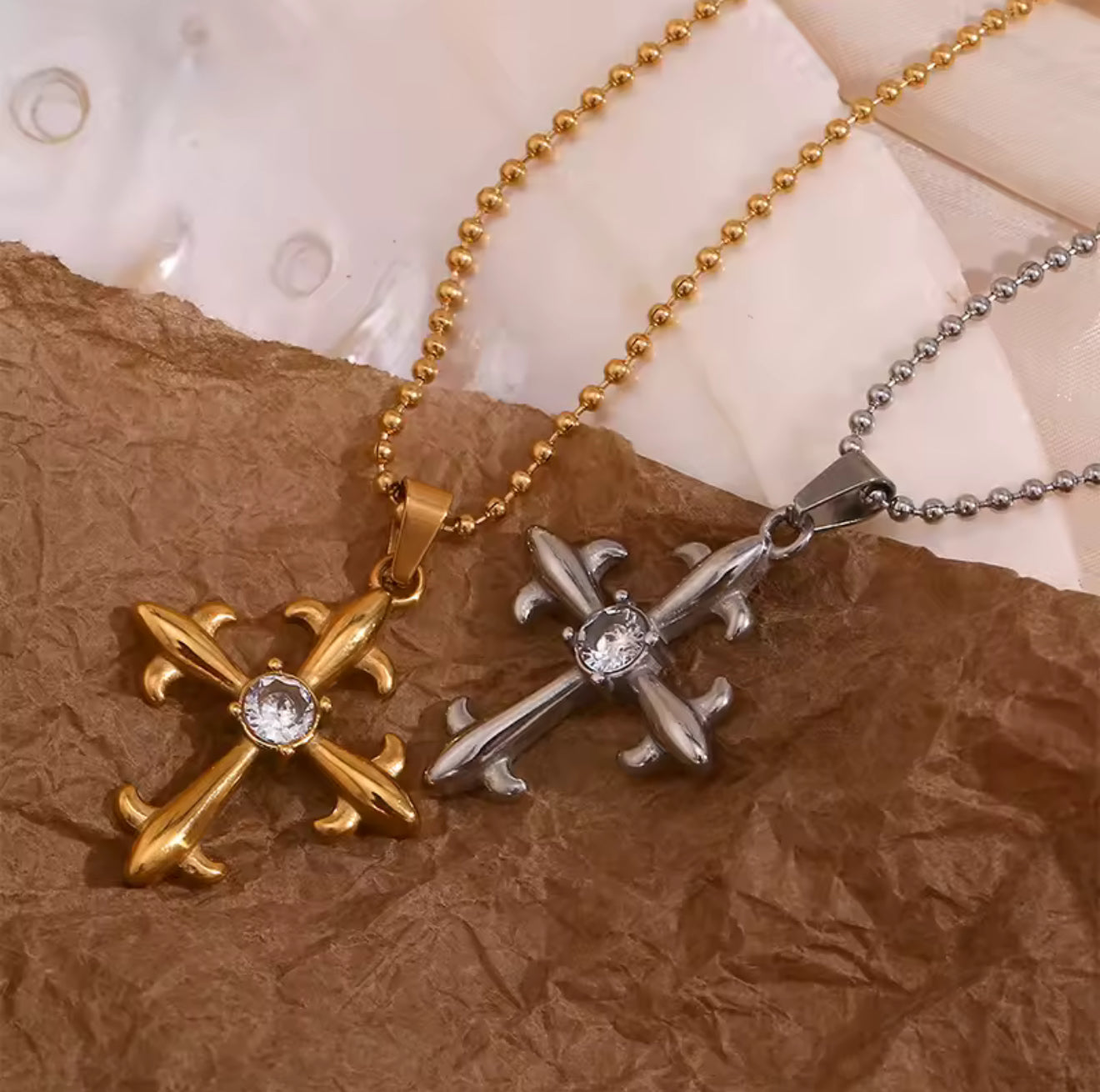 Detailed view of Lumière cross pendants with cubic zirconia center