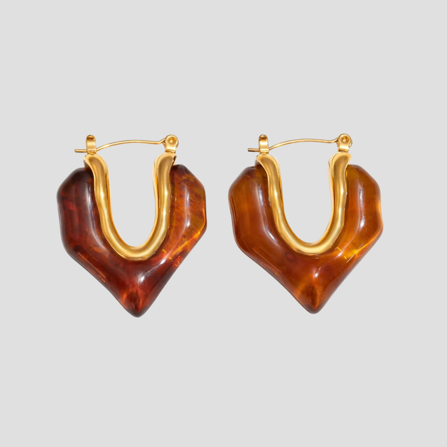 Gold molten heart amber resin hoop earrings on gray background