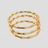 Three polished gold bamboo bangle bracelets stacked together, featuring sculptural segmented bamboo detailing on a light grey background by GRISÉ NYC.