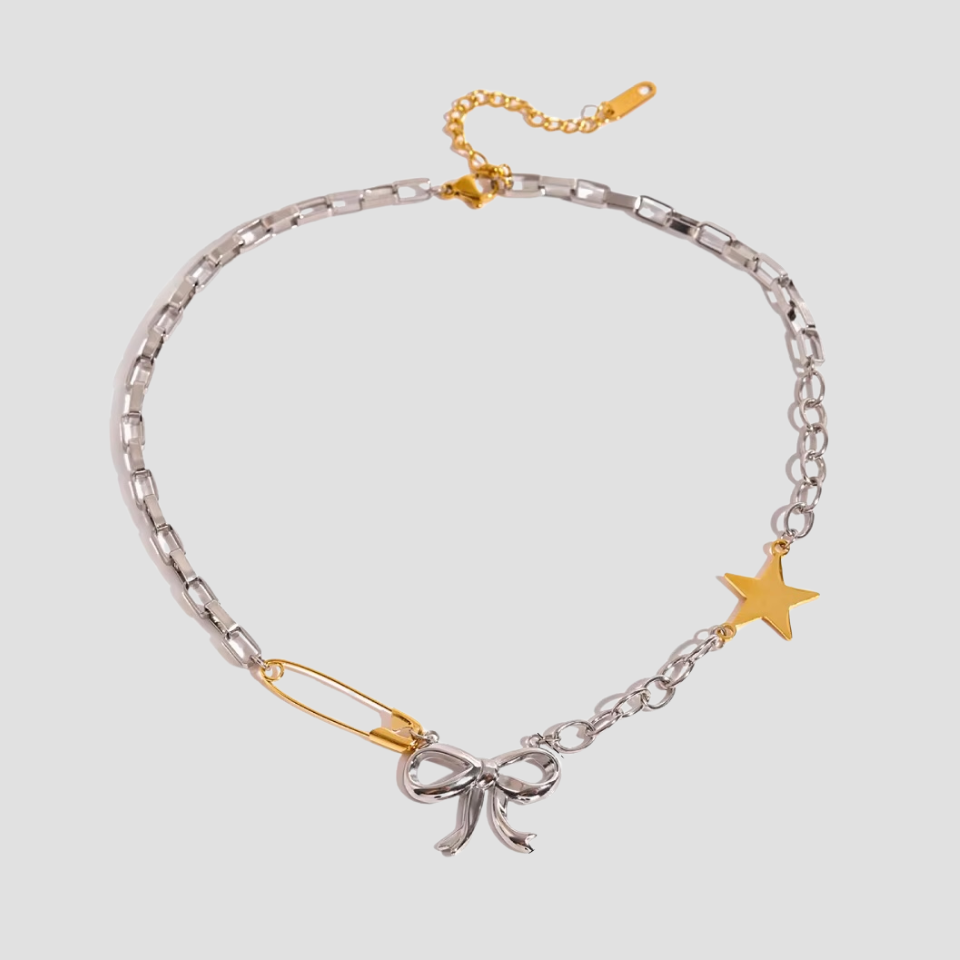 Detail shot of GRISÉ NYC bow pendant with star and safety pin charms.