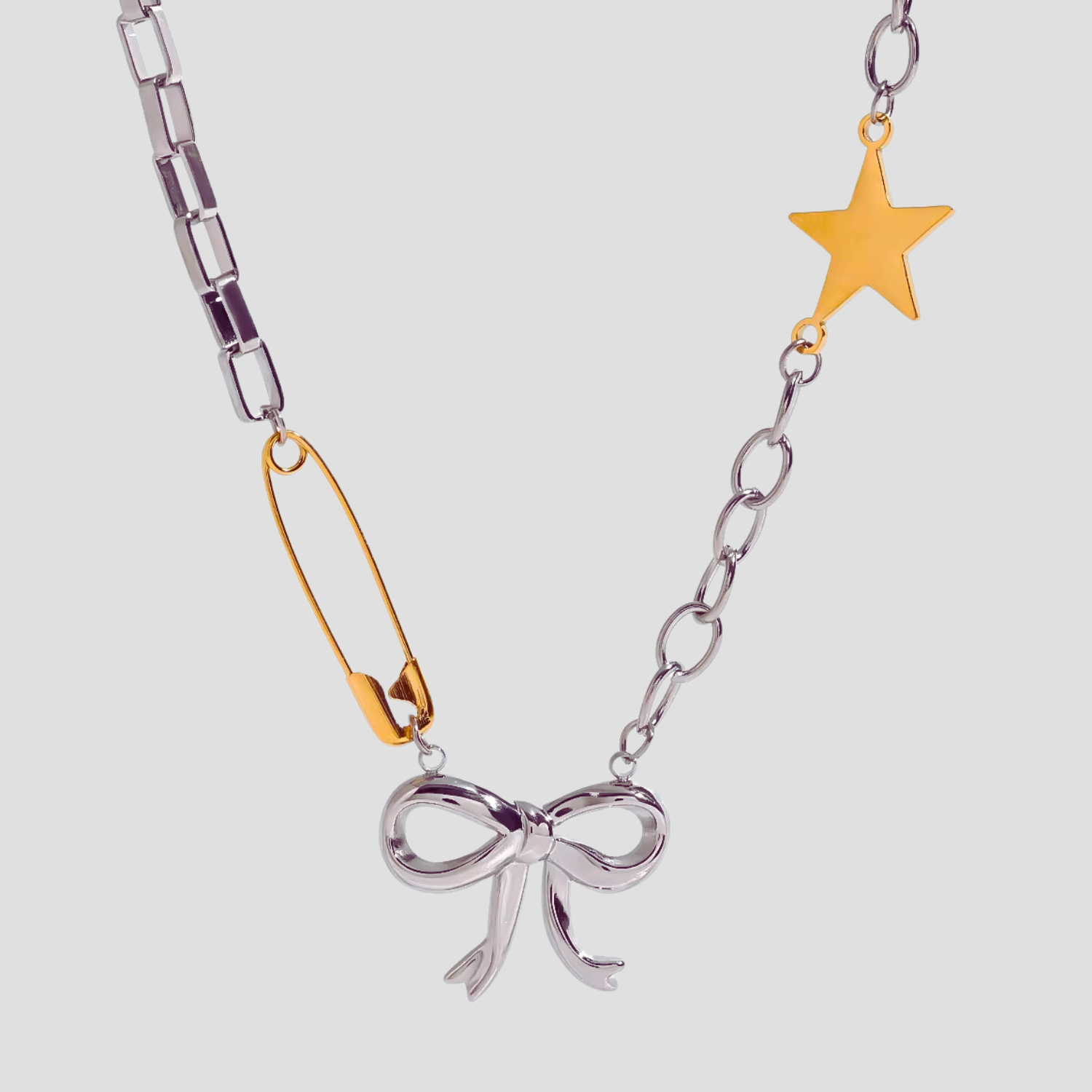 Flat lay of GRISÉ NYC 2-tone bow pendant charm necklace.