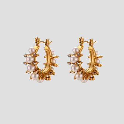 Adorned pearl hoop earrings in 18k gold plated stainless steel with simulated pearls and cubic zirconia accents by GRISÉ NYC.