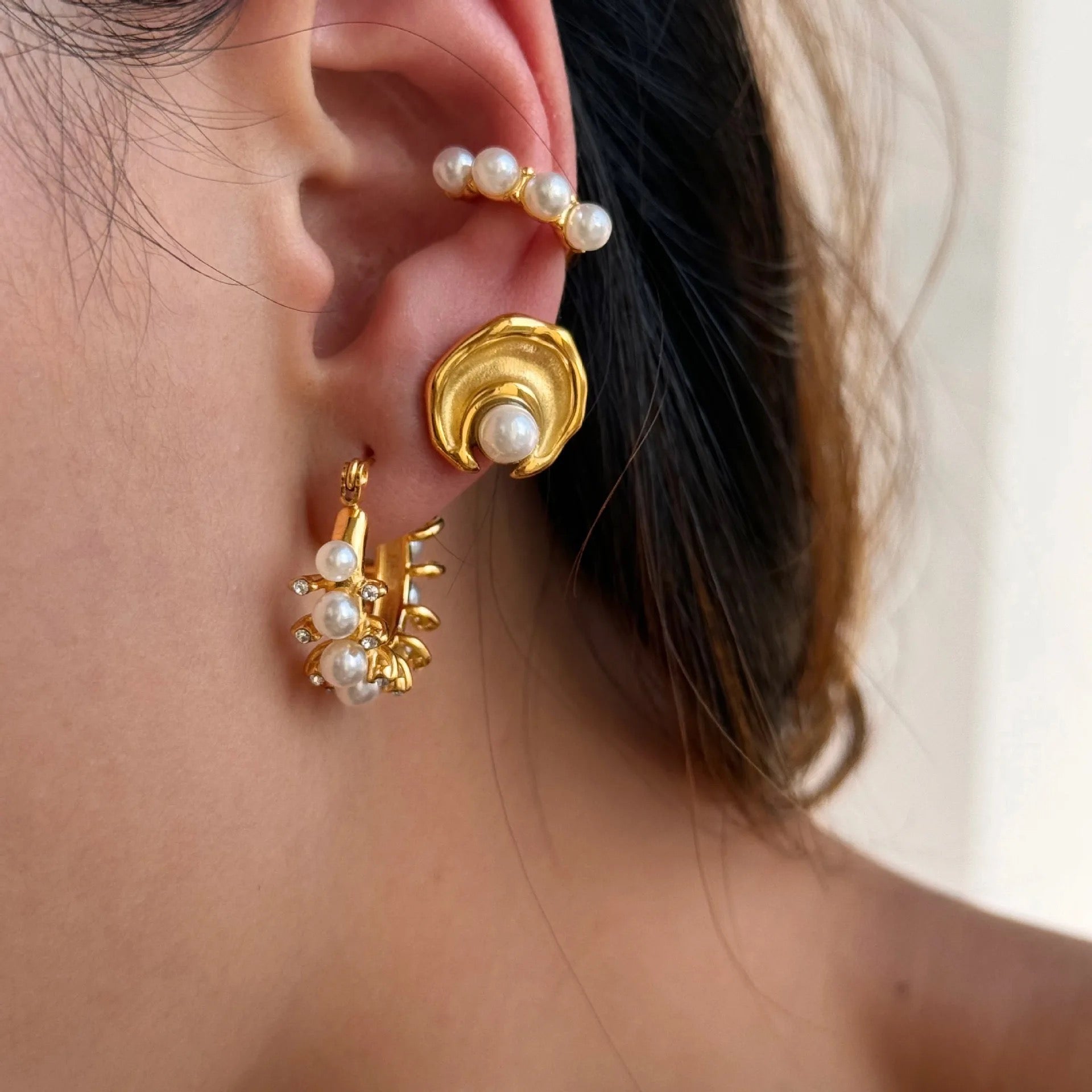 Model wearing adorned pearl hoop earrings with simulated pearls and gold plating by GRISÉ NYC.