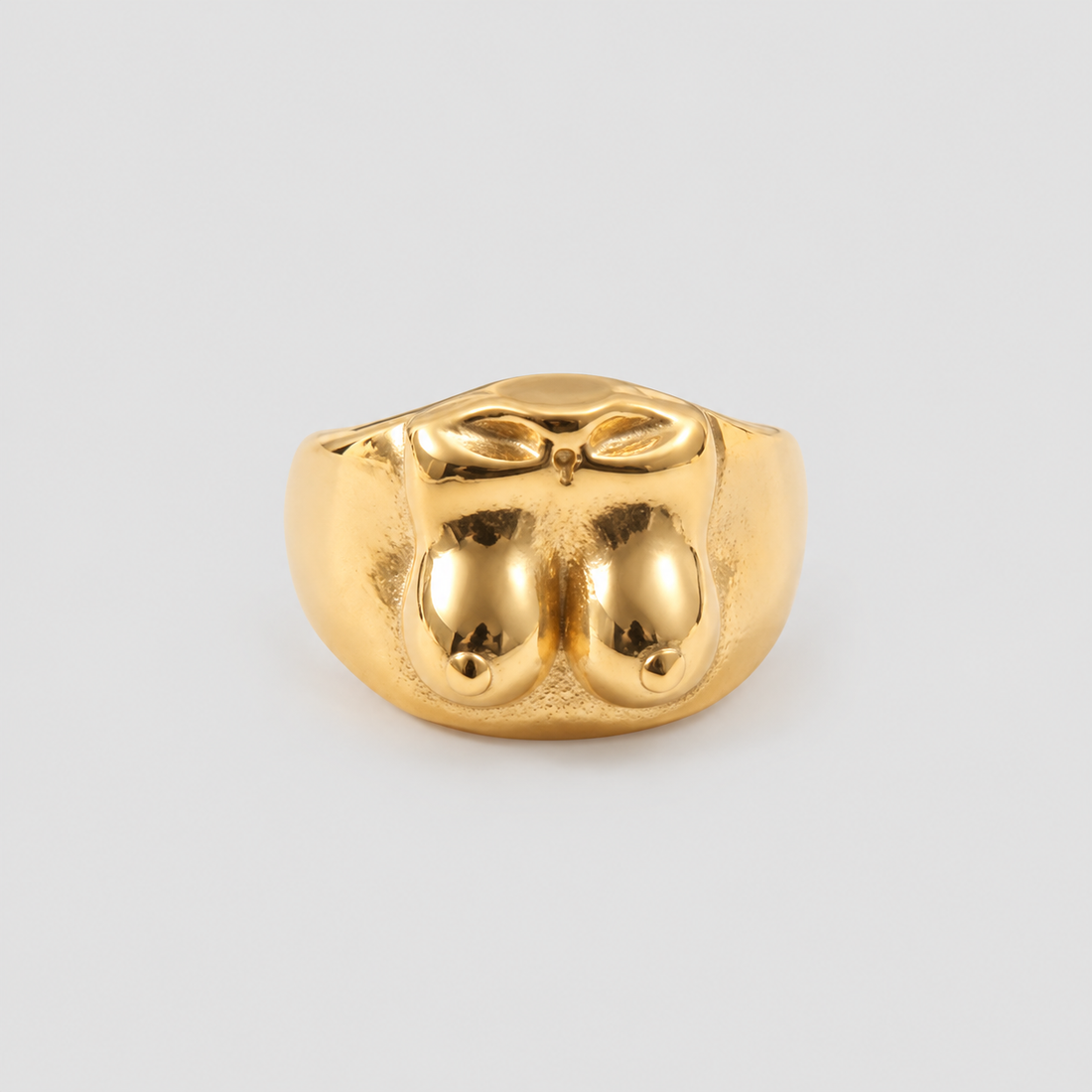 GRISÉ NYC Boobies Gold Plated Ring featuring a sculptural breast-inspired design with rounded curves and a polished gold finish on a light grey background.