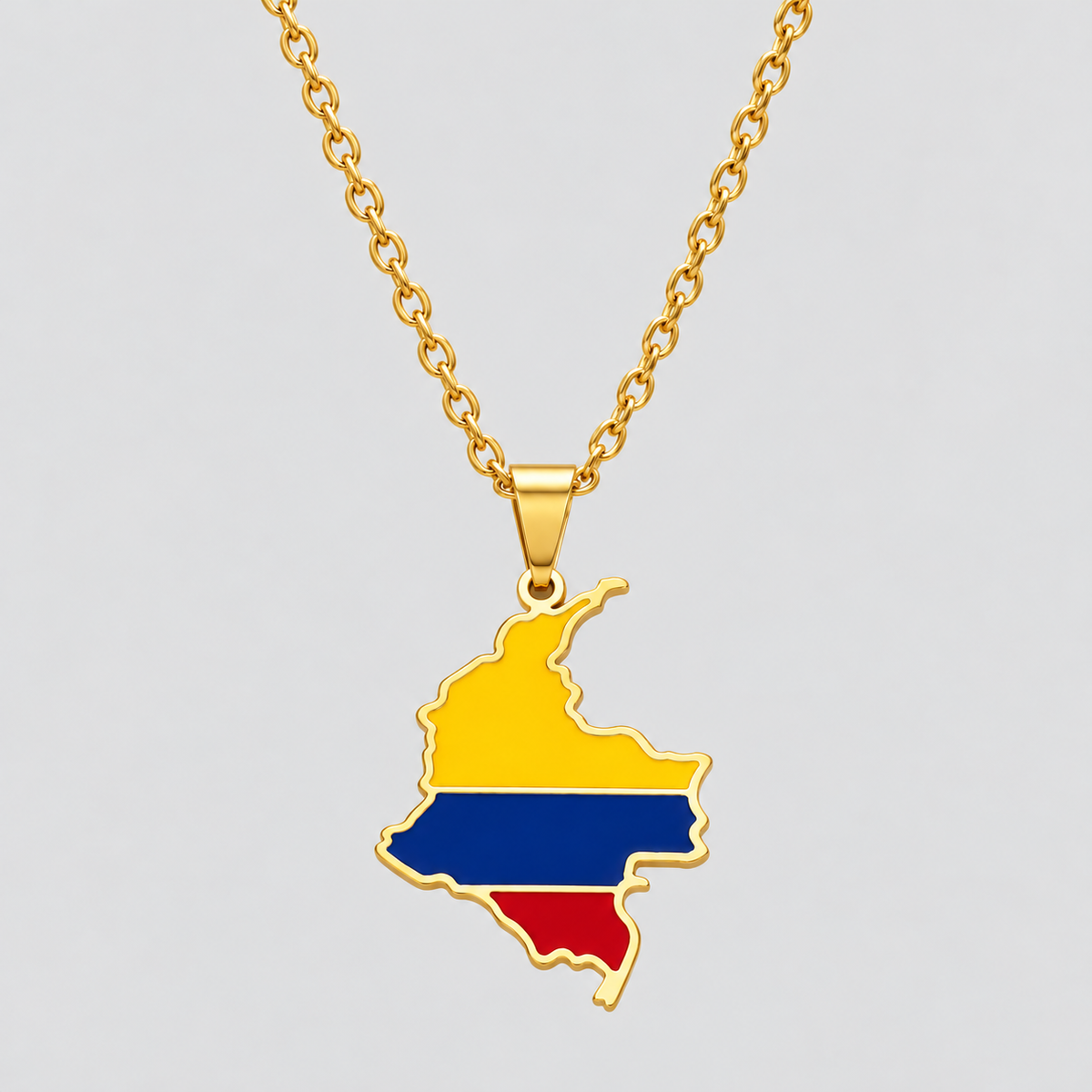 Gold Colombia flag map pendant necklace by GRISÉ NYC featuring yellow, blue, and red enamel detailing, polished gold-tone edges, and a gold cable chain on a light gray background.