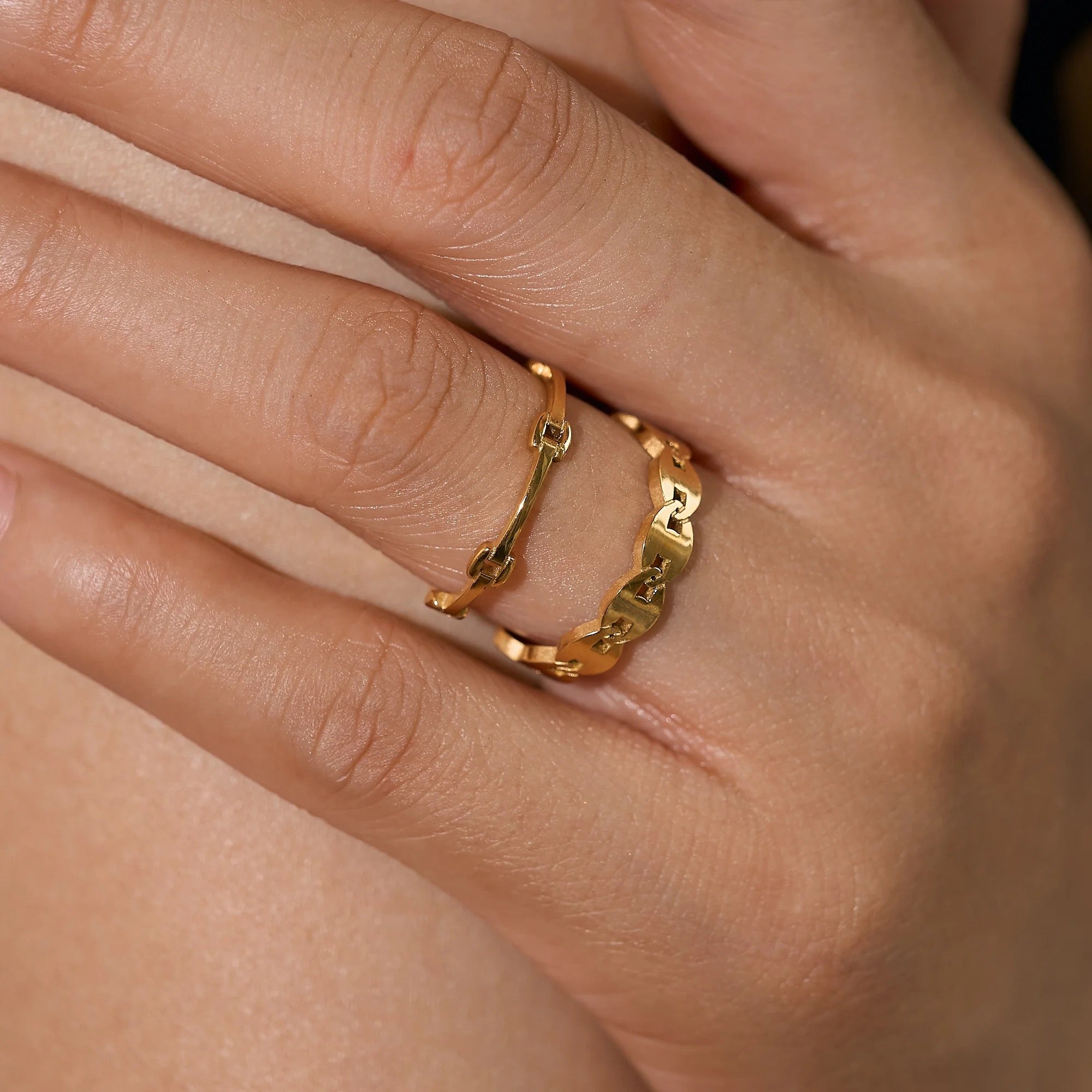 Model wearing the GRISÉ NYC Dainty Minimal Link 18k Gold Ring stacked with gold rings for a modern minimalist jewelry look.