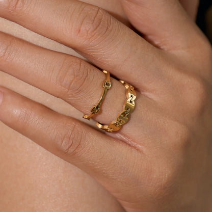 Model wearing the GRISÉ NYC Dainty Minimal Link 18k Gold Ring stacked with gold rings for a modern minimalist jewelry look.