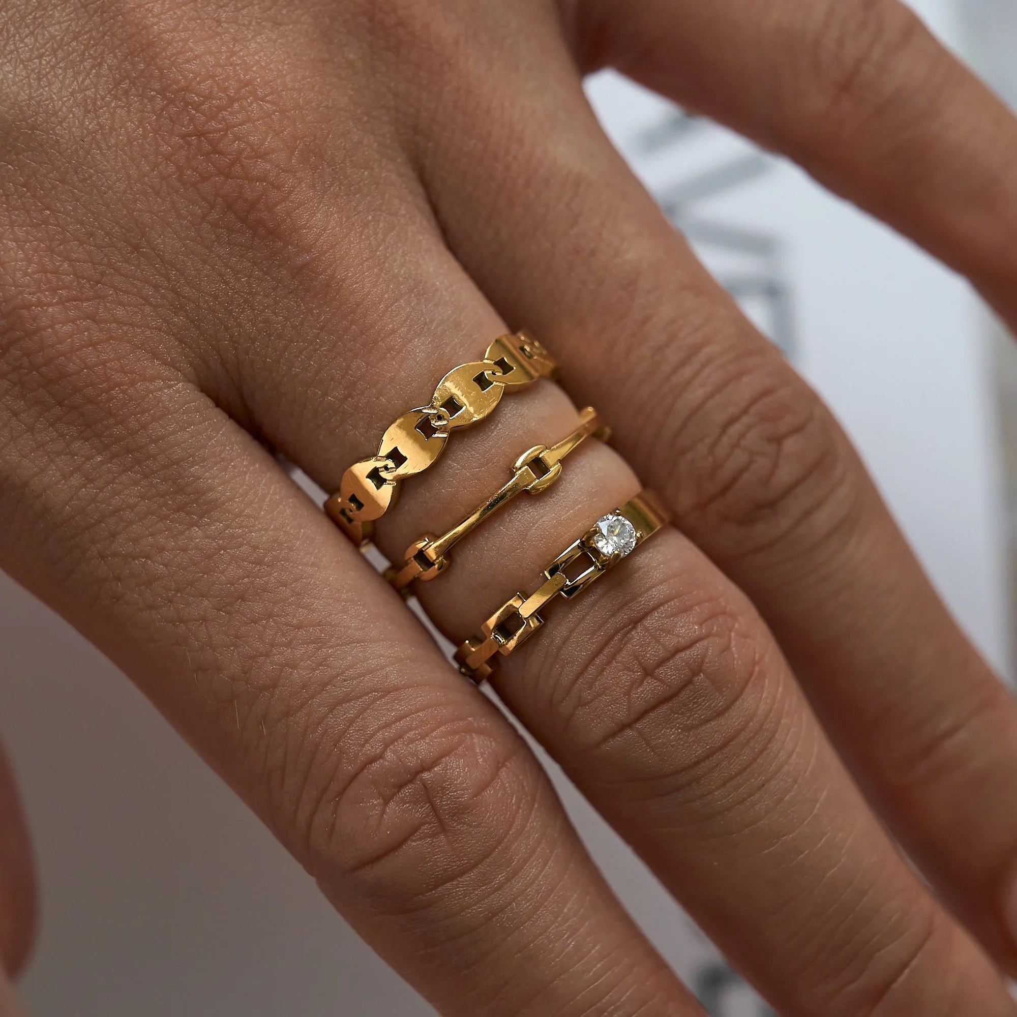 Model wearing the GRISÉ NYC Dainty Pigs Nose Link 18k Gold Ring, a minimalist stackable mariner link ring.