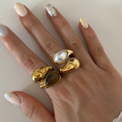 GRISÉ NYC Eclipse Rings stacked on hand featuring freshwater pearl and tiger’s eye stones in 18k gold plated stainless steel.