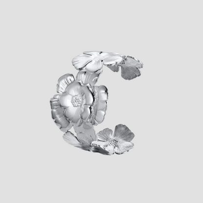 Flat lay of GRISÉ NYC embossed flower stainless steel cuff bracelet
