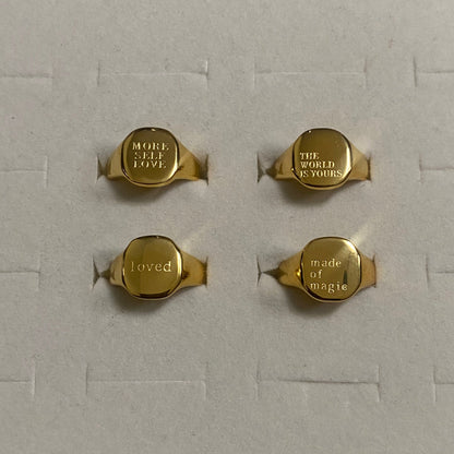 GRISÉ NYC gold engraved signet ring collection featuring MORE SELF LOVE, THE WORLD IS YOURS, loved and made of magic