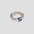 GRISÉ NYC evil eye resin ring with blue talisman detail, laid flat on gray background.