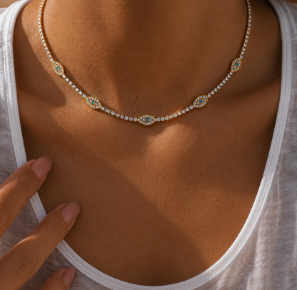 GRISÉ NYC Evil Eye Tennis Necklace in 18k gold plated stainless steel worn on model with a fitted white scoop neck top.