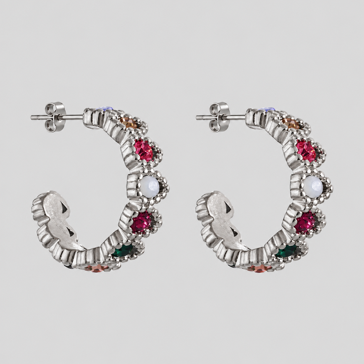 GRISÉ NYC Gemma Multicolor Hoop Earrings in polished silver stainless steel with vibrant pink, green, white and amber cubic zirconia stones, displayed on a light grey background.
