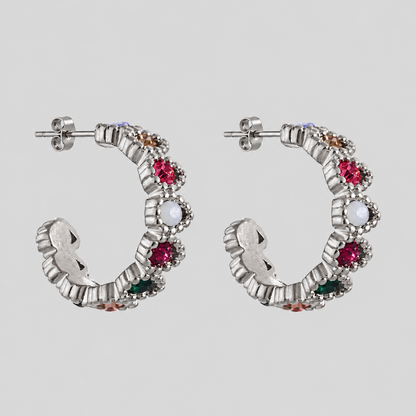 GRISÉ NYC Gemma Multicolor Hoop Earrings in polished silver stainless steel with vibrant pink, green, white and amber cubic zirconia stones, displayed on a light grey background.