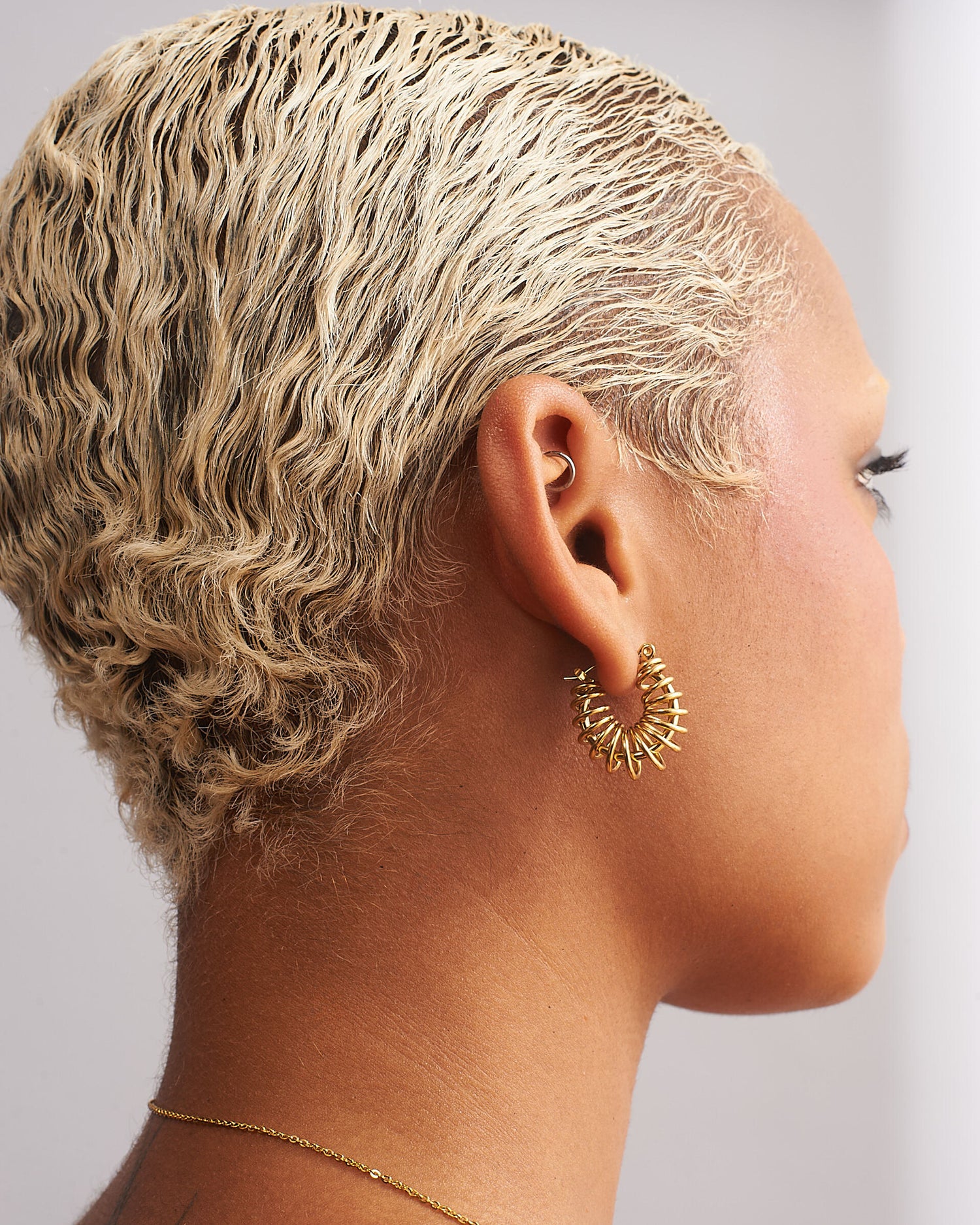 GRISÉ NYC gold barbed wire hoop earrings angled view showing sculptural wire detail